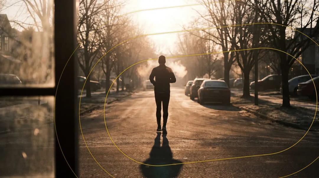 Runner heading down a frosty tree-lined street at dawn